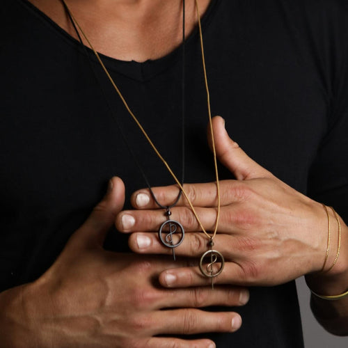 A model showcasing the 108 Talisman Necklaces in Black Ceramic and Antique Gold